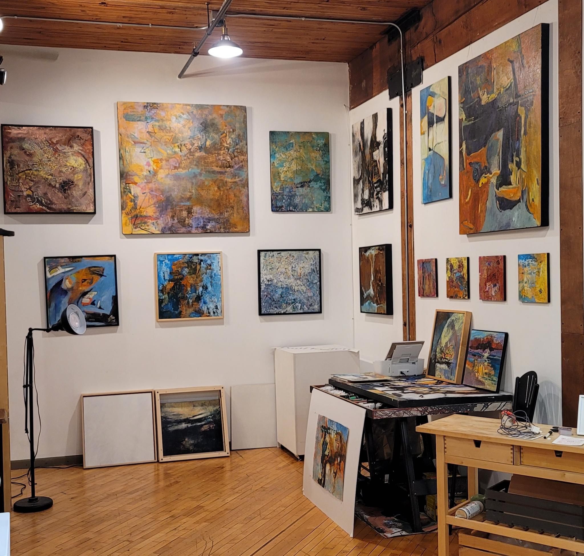 Paul Kellett's studio in Studiopolis (Studio 210) at the Northrup King Building, showing vibrant artwork on display walls and the artist's workspace with natural light from industrial windows
